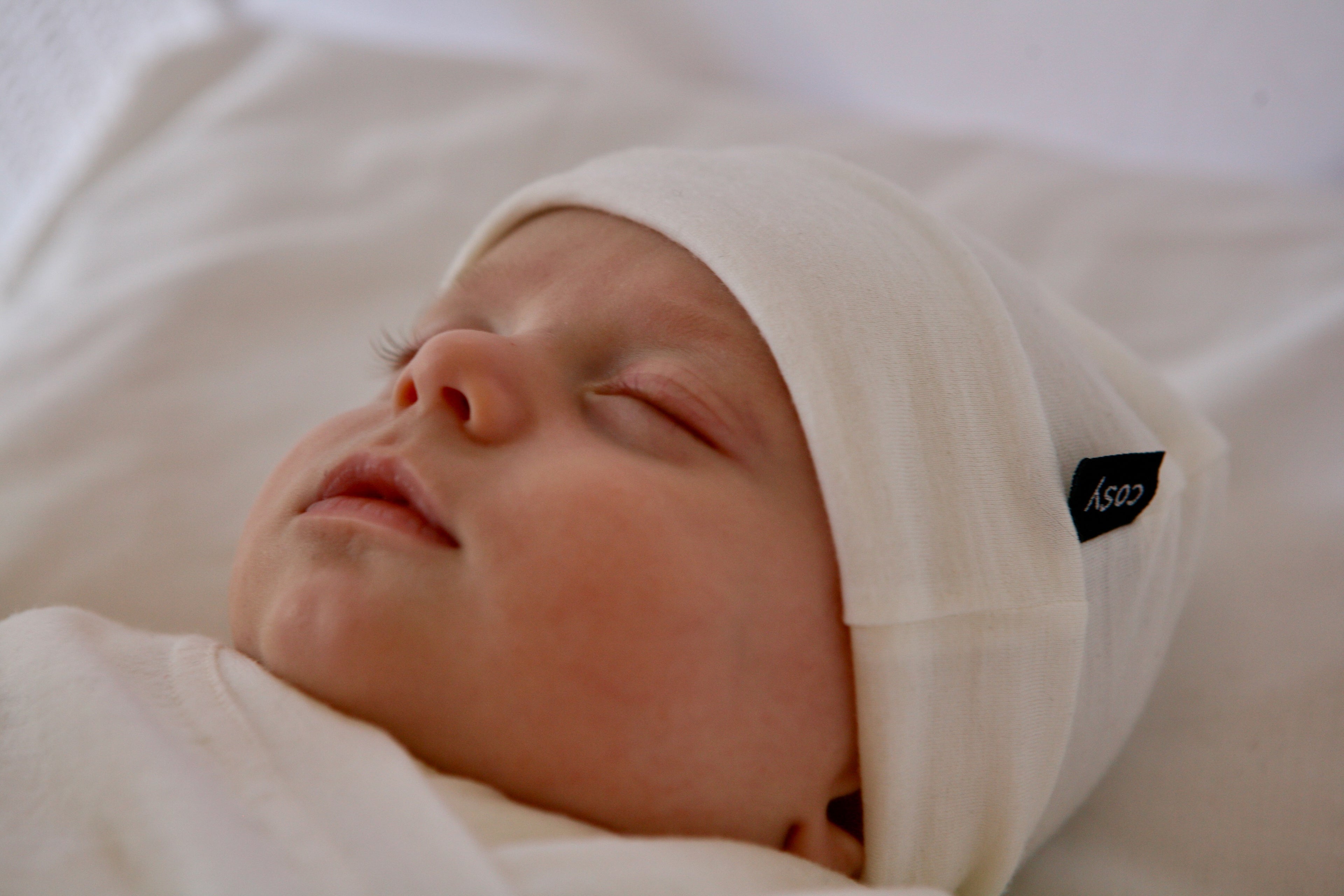 Sleeping baby wear a cream Merino Beanie