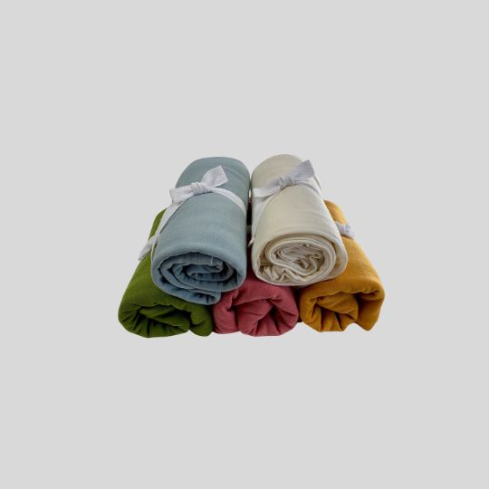 Rolled stake of Merino Baby Wraps in colours Duck Egg, Cream, Avocado, Guava and Marigold