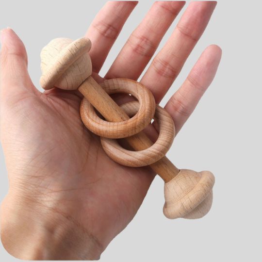 Adults hand holding a Wooden Rattle