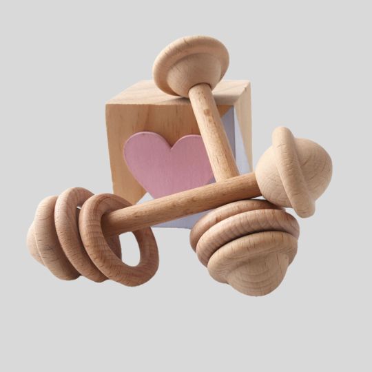 Two Wooden Rattles leaning against a wooden block